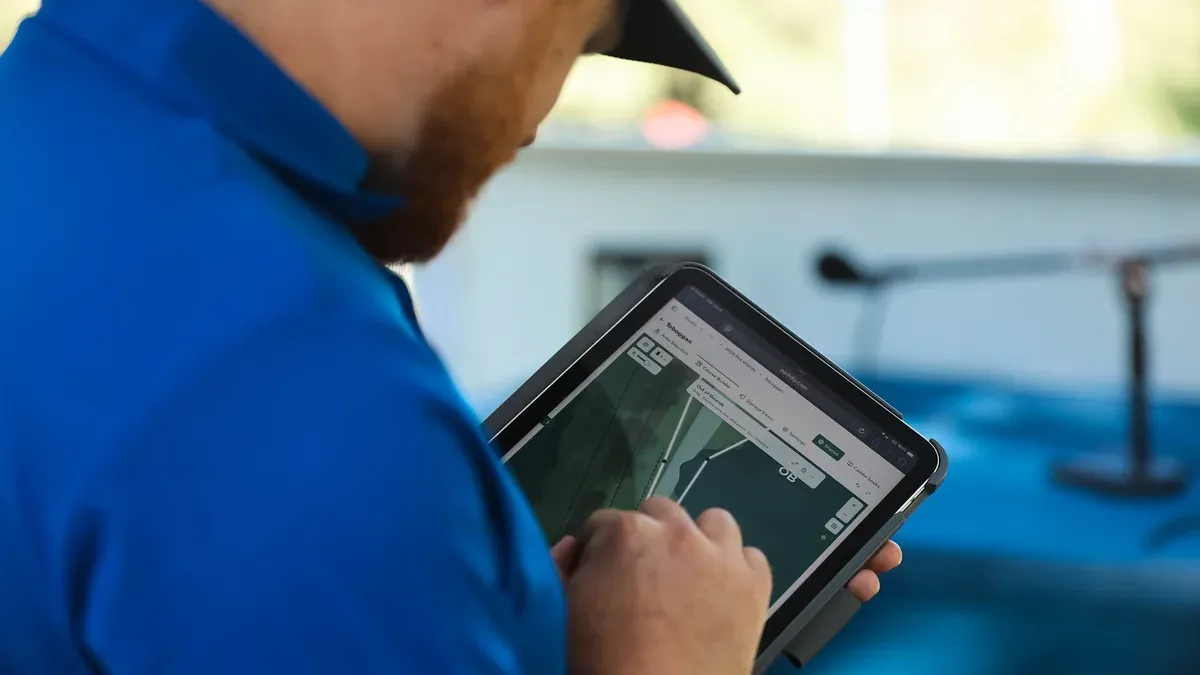 A course designer adjusting an OB line on a tablet, on site at the 2026 PDGA Pro Worlds